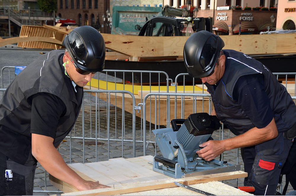 Dachdecker beim Zusaegen der Bauteile